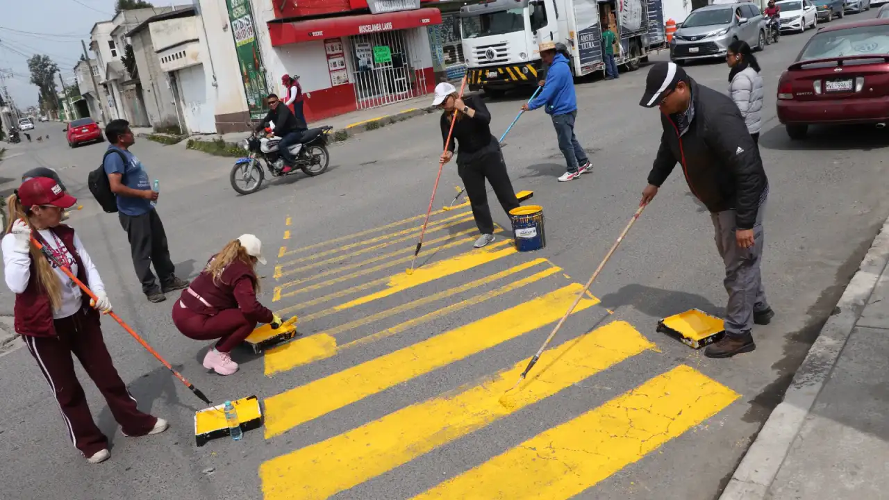 Vecinos y servidores públicos durante labores de limpieza en una calle de Toluca
