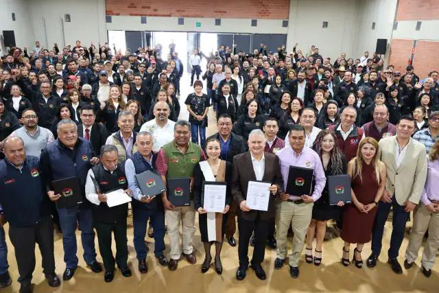 Firma de convenio entre autoridades municipales y sindicato en un evento público