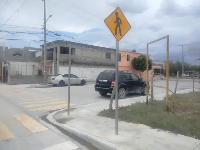 Operarios colocan un poste de señalización vial en una esquina de Reynosa