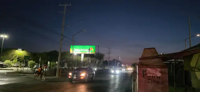 Trabajadores municipales instalando lámparas LED en un poste de alumbrado público