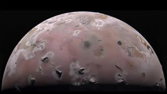 Ilustración de la sonda Juno sobrevolando la luna Ío con Júpiter al fondo