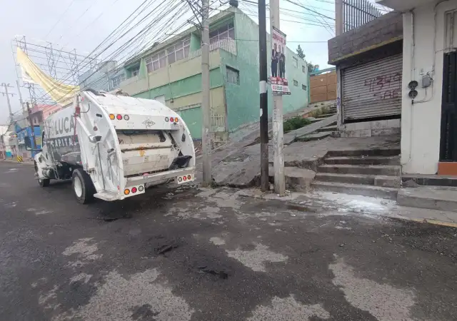 Camión de recolección de residuos circulando por una calle de Toluca